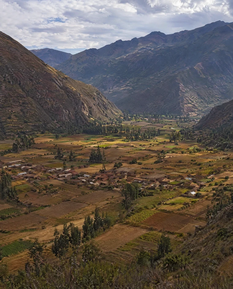 Paisagem do Vale Sagrado dos Incas no Peru com montanhas, campos agrícolas e vilarejo andino