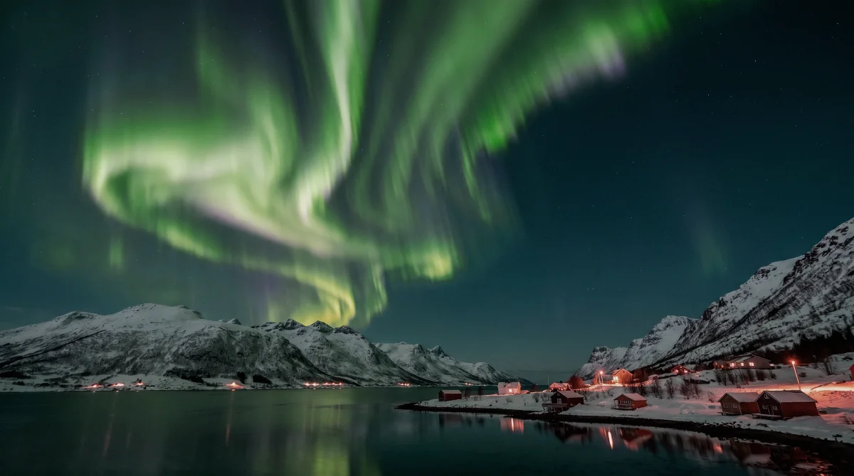 Aurora boreal sobre paisagem nevada em Tromsø, na Noruega